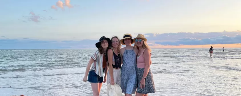 A group of women standing on top of a beach
