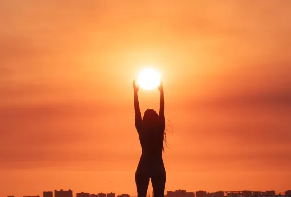 A person standing on a beach at sunset