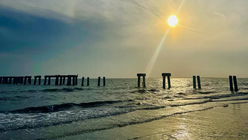 View from Crescent Beach Park of Pier in 2023 on Fort Myesr Beach with Sun setting